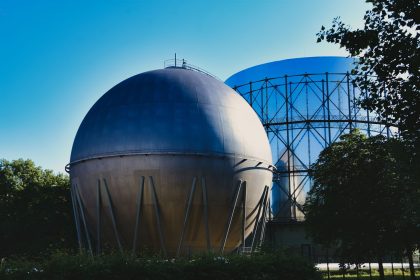 Gasômetros industriais em uma instalação energética sob céu azul.