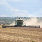Colheitadeira trabalhando em uma extensa lavoura de soja no Brasil.