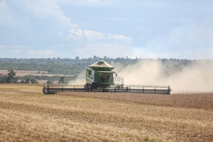Colheitadeira trabalhando em uma extensa lavoura de soja no Brasil.