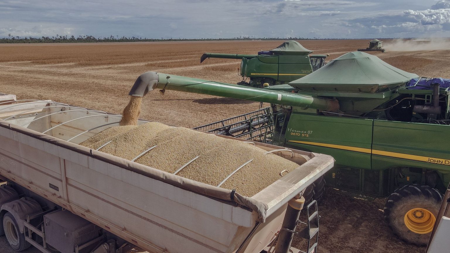 Colheitadeiras transferem soja colhida para um caminhão em uma propriedade rural de Paragominas, no Pará.